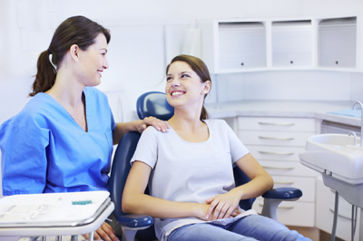 A lovely dentist reassuring her pretty young patient about the procedure